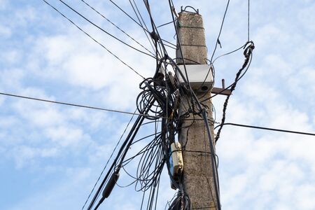pole with many wires against the skyの写真素材