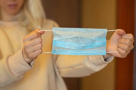 hand holds medical mask indoorsの写真素材