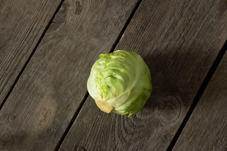 head of young green cabbage lies on a wooden boardの写真素材