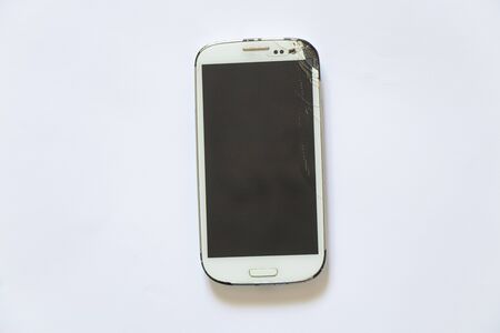 broken white phone after falling on a white backgroundの写真素材