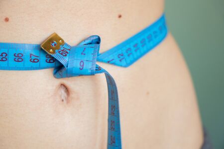 skinny belly of a young girl with a centimeterの写真素材