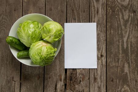 cabbage with cucumbers in a white plate on a wooden tableの写真素材