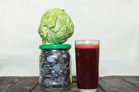 freshly squeezed beet juice and a can with Ukrainian coinsの写真素材