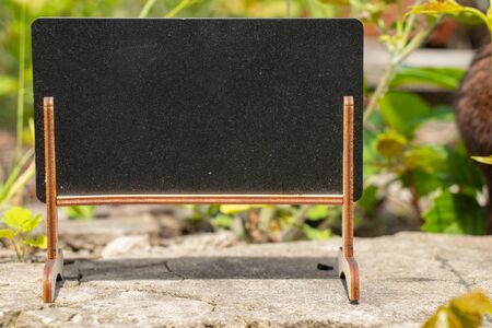 empty little school blackboard with place for text stands outdoorsの写真素材