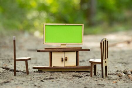 TV table and chair in miniature made of wood stand on the ground in a foxの写真素材