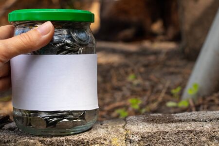 jar with Ukrainian coins and a white label with place for text standsの写真素材