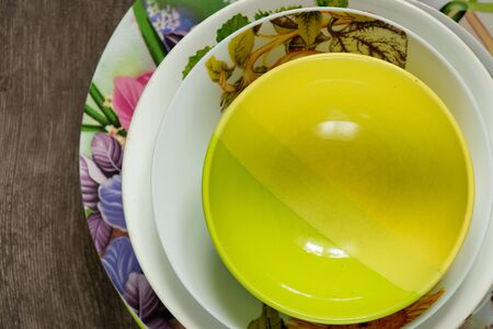 stack of old home plates on a wooden tableの写真素材
