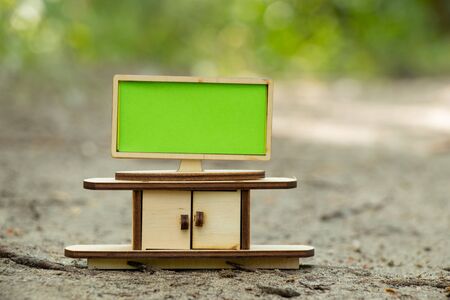 tv and a small children's wooden bedside table stand in the forest in the sun with an empty place for textの写真素材