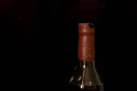 the neck of an old bottle of whiskey 1939 macro photo on a blackの写真素材