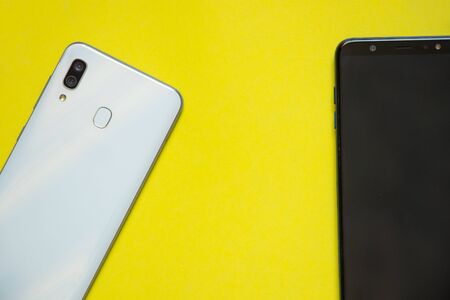 phones on a yellow background close-up place for textの写真素材
