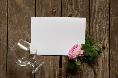 glass and tea rose and empty white sheet for text on a tableの写真素材