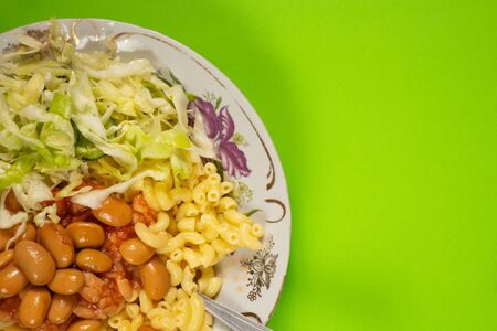 pasta and cabbage with beans on a plate on a greenの写真素材
