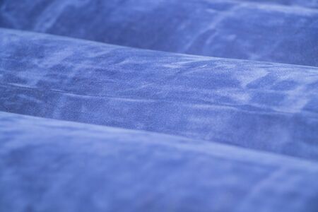 plain dark blue fabric made of artificial materials as a wallpaper