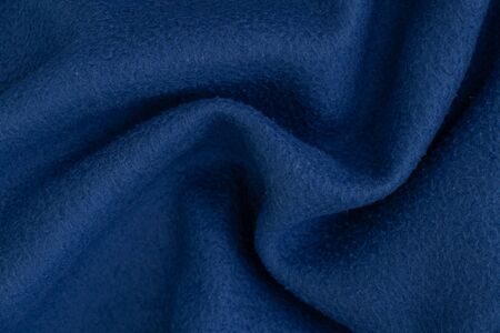 plain dark blue fabric made of artificial materials as a wallpaperの写真素材