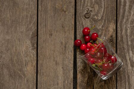 cherry in a glass on an wooden tableの写真素材