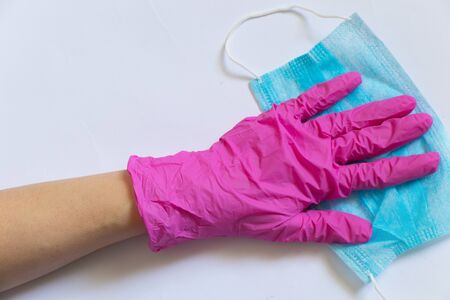 medical protective blue mask and female hand in black gloves on a white background close-upの写真素材