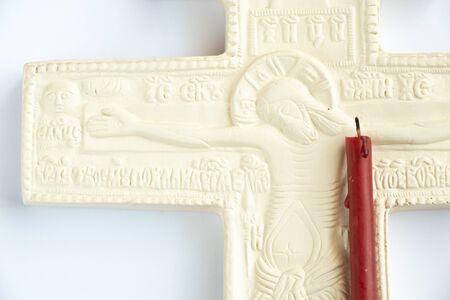 christian plaster cross and church candle on a white background close-upの写真素材