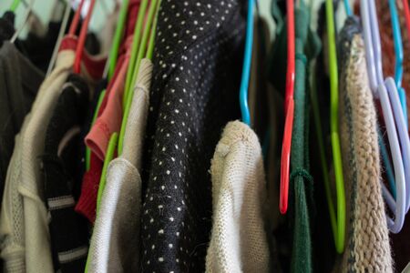 different clothes on metal hangers in a room