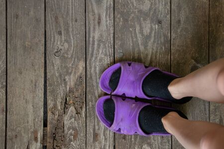 bare feet in socks and flip flops on the old wooden floorの写真素材