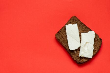 piece of black bread with feta cheese on a red
