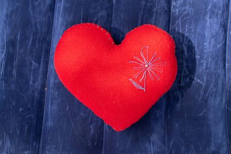 red heart-shaped pillow on a blue backgroundの写真素材