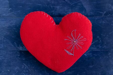 red heart-shaped pillow on a blue backgroundの写真素材