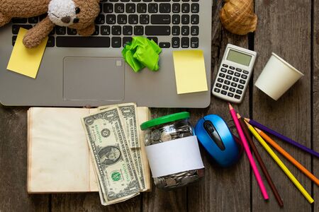 mess on the desktop laptop pencils and money paperの写真素材