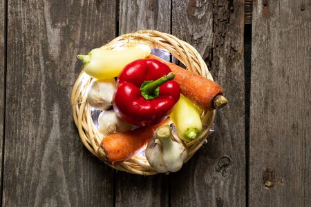 pepper carrots garlic from the vegetable garden lie on an old wooden tableの写真素材