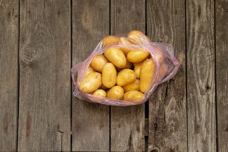 a young potato in a bag on a table bought at a bazaarの写真素材