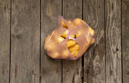 a young potato in a bag on a table bought at a bazaarの写真素材