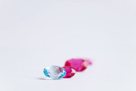 precious faceted pink stones of various shapes and sizes on a white backgroundの写真素材