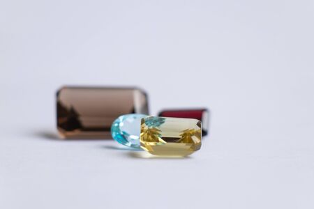 faceted precious stones of various shapes and sizes on a white background topaz aquamarineの写真素材