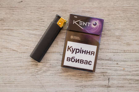 Ukraine, Dnipro - July 02, 2020. pack of kent cigarettes and a lighter on the table, smoking addictionのeditorial素材