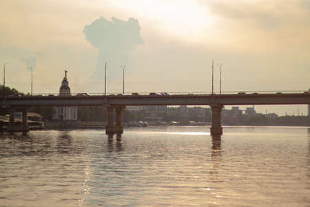 old bridge over the Dnieper river in the city of Dnieper at sunset on the city background in the summerの写真素材