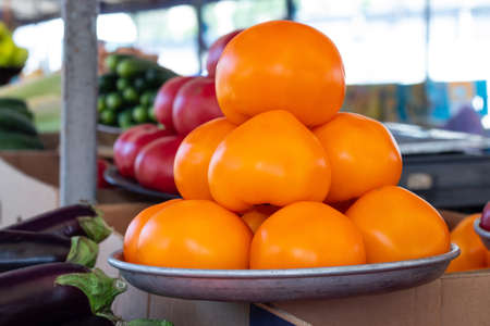 yellow tomatoes in the bazaar in a plate on a display caseの写真素材