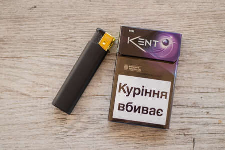 Ukraine, Dnipro - July 02, 2020.a pack of kent cigarettes and a lighter on the table, smoking addictionのeditorial素材