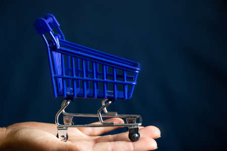 supermarket trolley blue and hand on a isolated backgroundの写真素材