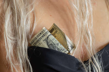 dollar bills in a bra of a young girl close-up of a prostituteの写真素材
