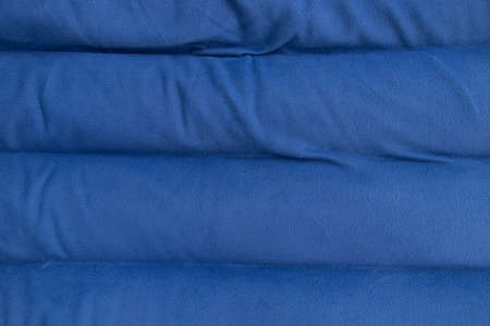 plain dark blue fabric made of artificial materials as wallpaper close-upの写真素材