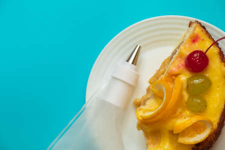 piece of fruit cake and pastry bag on colored background for birthdayの写真素材