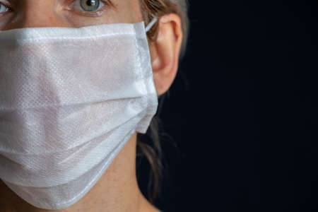 Ukrainian girl in medical mask portrait on dark