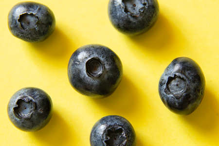 ripe blueberries on a yellow background close upの写真素材