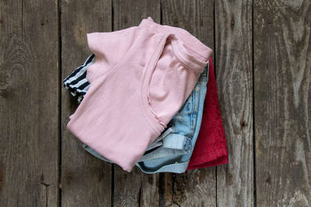 womens t-shirt and denim shorts lay on rustic brown background, womens clothing, fashion, many womens thingsの写真素材