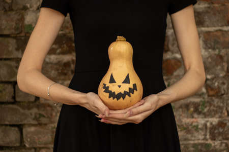 pumpkin in the hands of a girl painted for halloween, halloween holiday in ukraine