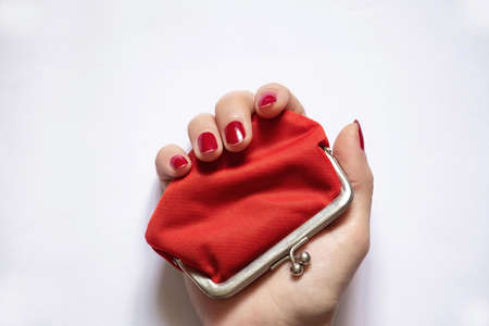 red old wallet and female hand on isolated background close up