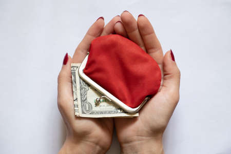 american dollars in red female wallet and woman hand on isolated background close-upの写真素材