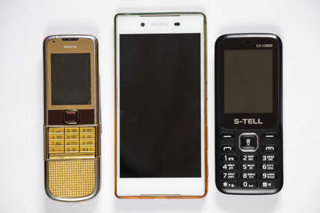 Ukraine Dnepr 10/23/2020 - Nokia 8800 gold and sony lies on an isolated background, several different phones from different timesのeditorial素材
