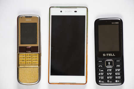 Ukraine Dnepr 10/23/2020 - Nokia 8800 gold and sony lies on an isolated background, several different phones from different timesのeditorial素材