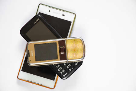 Ukraine Dnepr 10/23/2020 - Nokia 8800 gold and sony lies on an isolated background, several different phones from different timesのeditorial素材
