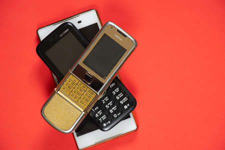 Ukraine Dnepr 10/23/2020 - Nokia 8800 gold and sony lies on an isolated background, several different phones from different timesのeditorial素材